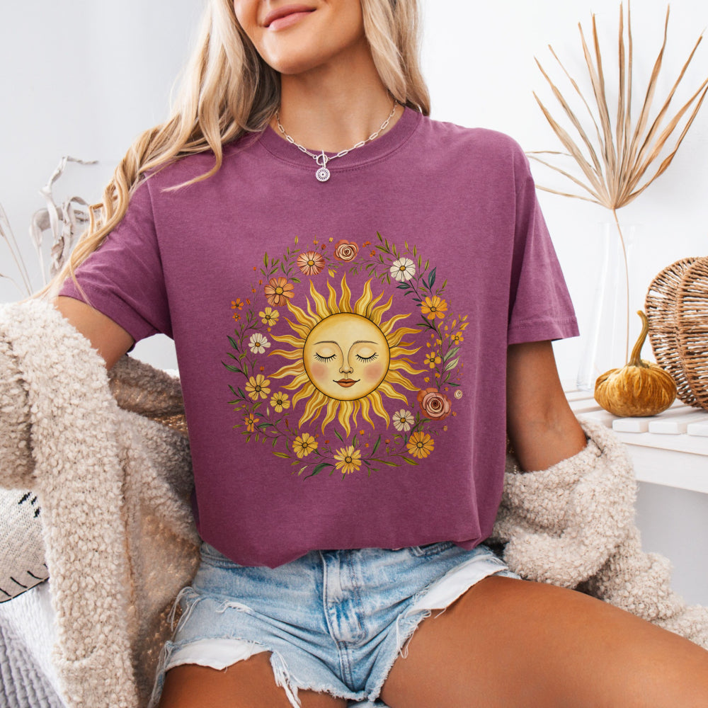 Woman wearing a Berry Comfort Colors 1717 tee with a vintage sun and floral graphic